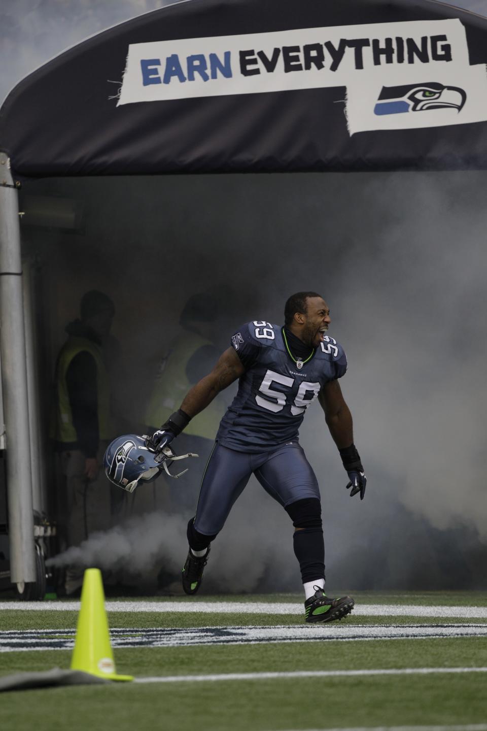 FILE - Seattle Seahawks Aaron Curry runs onto the field before their NFL football game against the Carolina Panthers, Sunday, Dec. 5, 2010, in Seattle. Aaron Curry imagines a day in the future standing at the front of the room using his measured voice and commanding presence in a role his current boss would not have imagined a decade ago. Pete Carroll never thought of Curry as a potential coach when he was a player for the Seattle Seahawks. Curry started with the basics of breaking down film and putting together practice plans, but has moved on to doing more individual work with defensive ends alongside defensive line coach Clint Hurtt. (AP Photo/Elaine Thompson, File)