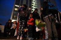 Residents leave the Taplow Tower residential block on the Chalcots Estate in north London on June 23, 2017 as it is evacuated because of fire safety concerns