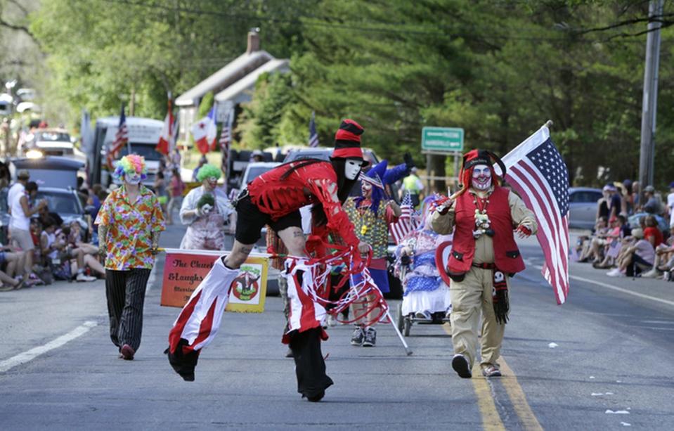 Members of Chuckles and Show (with John Stogner on stilts) won the best walking group trophy for the parade make their way along South Main Street in the 90th edition of the Ancients & Horribles parade in Glocester in 2016.