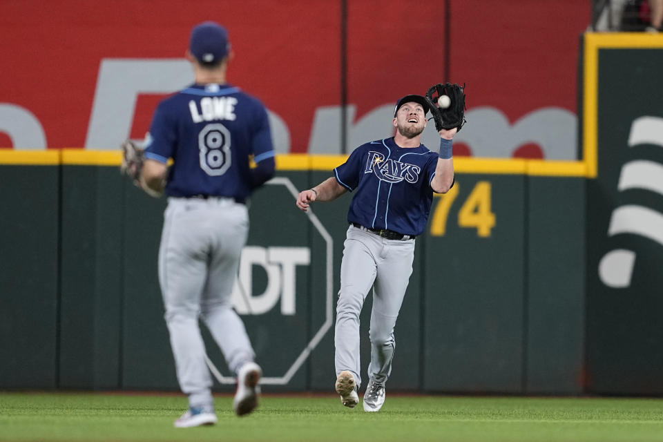 Tampa Bay Rays right fielder Luke Raley catches a fly ball hit by Texas Rangers' Marcus Semien as Brandon Lowe (8) watches during the first inning of a baseball game Tuesday, July 18, 2023, in Arlington, Texas. (AP Photo/Tony Gutierrez)