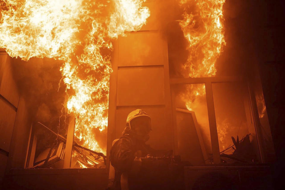 In this image provided by the Ukrainian Emergency Service, a firefighter works to extinguish a fire after a Russian attack in Odesa, Ukraine, Thursday, July 20, 2023. (Pavlo Petrov/Ukrainian Emergency Service via AP)