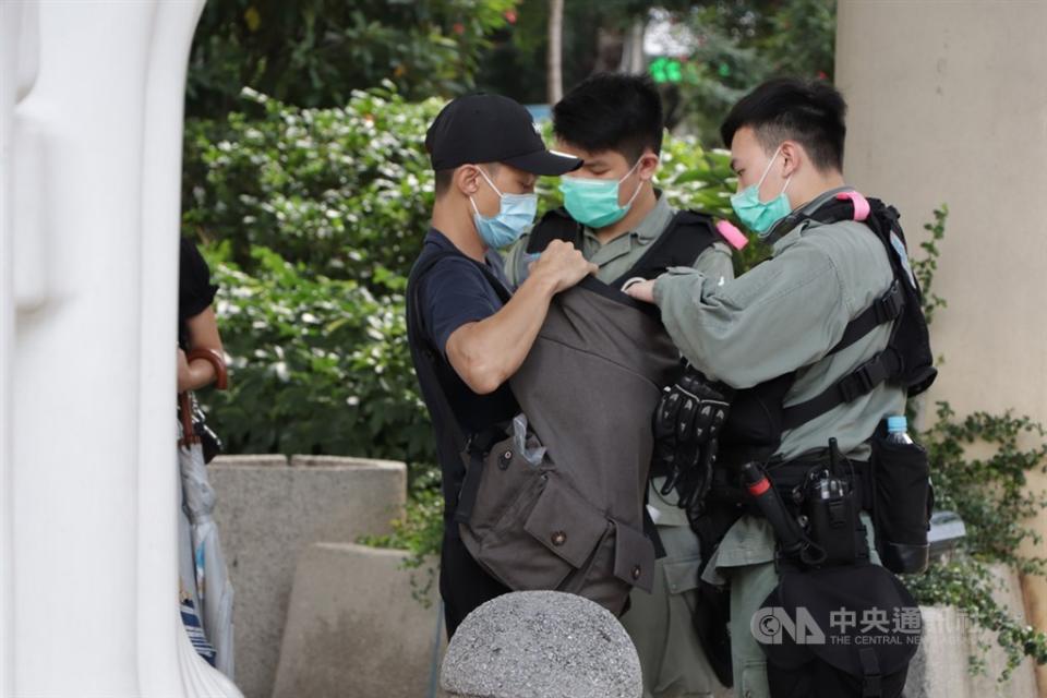 香港立法會今天恢復二讀辯論「國歌條例草案」，有人發起包圍議會，以示抗議，警方派出約3000名警員布防，圖為防暴警察在灣仔截查可疑示威者。(中央社)