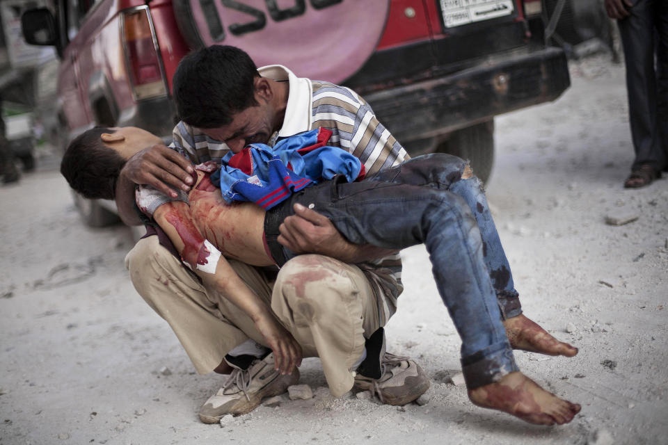 FILE - A man cries over the body of his son near Dar El Shifa hospital in Aleppo, Syria, Oct. 3, 2012. Three suicide bombers detonated cars in a government-controlled area of the battleground city, killing at least 34 people, leveling buildings and trapping survivors under the rubble. More than 120 people were injured. (AP Photo/Manu Brabo, File)