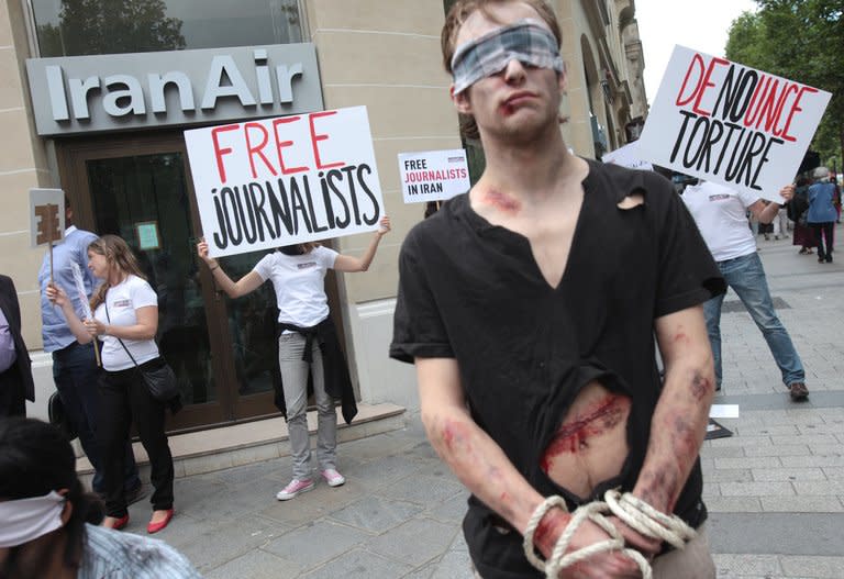 Activists from Reporters Without Borders (Reporters Sans Frontieres- RSF) protest in front of an Iran Air agency in Paris, on July 10, 2012. Democracy around the world was in decline in 2012 for the seventh year in a row as the Arab Spring led nervous autocratic leaders to clamp down on any stirrings of dissent, a study said Wednesday