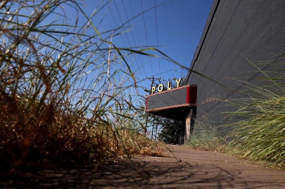 Overgrown grass lines the sidewalk to the Poly Theater on Wednesday, August 3, 2023. The Poly Theater operated from 1951 until around 1984.