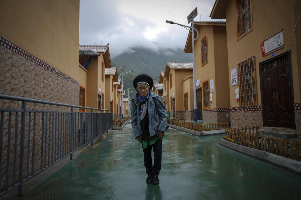 A minority woman stands in between new village houses in Ganluo county, southwest China's Sichuan province on Sept. 10, 2020. China's ruling Communist Party says its initiatives have helped to lift millions of people out of poverty. Yi ethnic minority members were moved out of their mountain villages in China’s southwest and into the newly built town in an anti-poverty initiative. (AP Photo/Andy Wong)