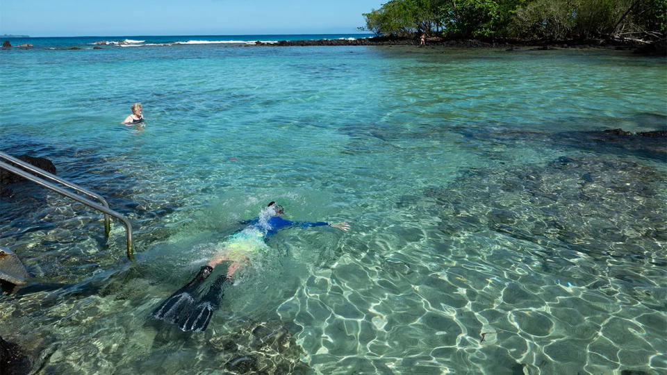 A man snorkels in the clear water of the Pacific Ocean at Carlsmith Beach Park on January 15, 2024 in Hilo, Hawaii.