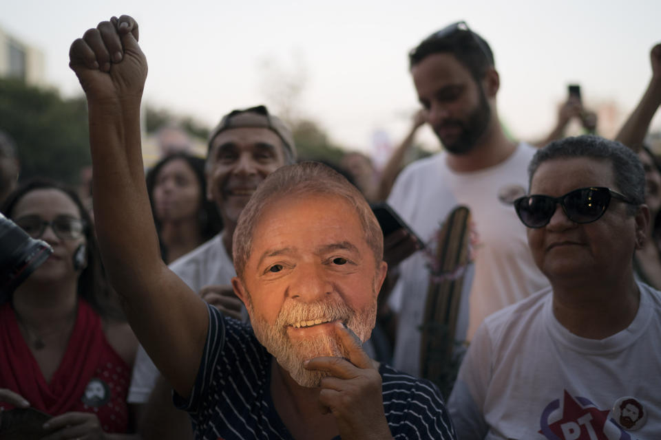 A supporter wears a mask depicting former Brazilian President Luiz Inacio da Silva during the Lula Free festival in Rio de Janeiro, Brazil, Saturday, July 28, 2018. Popular Brazilian musicians and social movements organized a concert to call for the release of da Silva, who has been in prison since April, but continues to lead the preferences on the polls ahead of October's election. (AP Photo/Leo Correa)