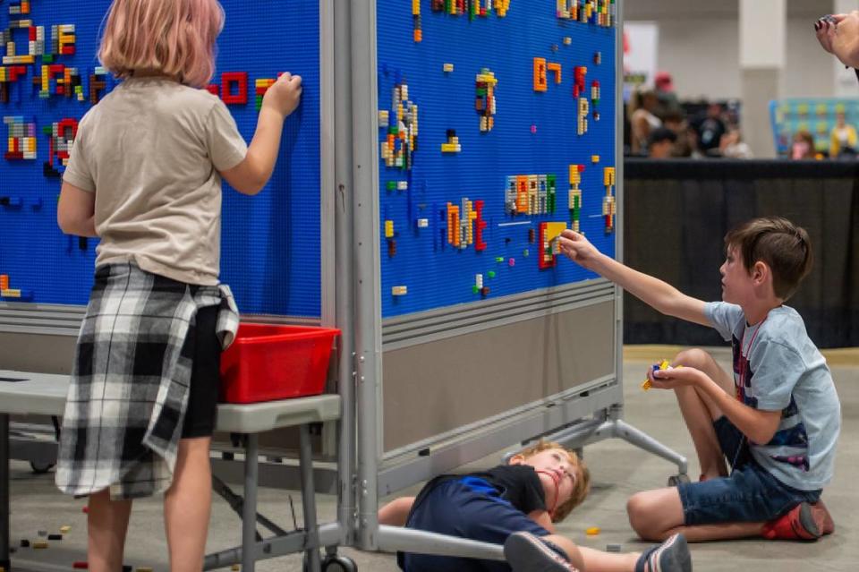 Declan Flowers, right, 8, adds to the Lego name wall while his brother Grayson, 4, watches while resting at the Brick Fest Live on Sunday, Oct. 2, 2022, at SAFE Credit Union Convention Center in downtown Sacramento.