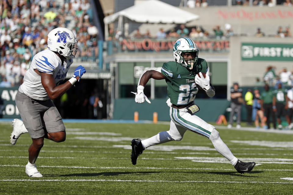 Tulane running back Tyjae Spears (22) runs the ball past Memphis linebacker Xavier Cullens (8) during the first half of an NCAA college football in New Orleans, Saturday, Oct. 22, 2022. (AP Photo/Tyler Kaufman)