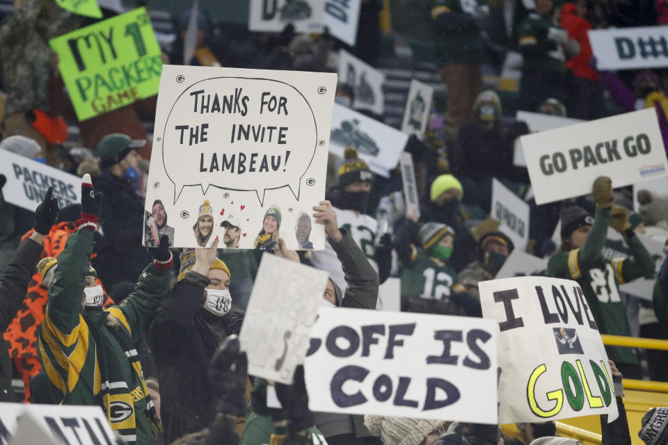 Packers' fans hold up signs during the first half of an NFL divisional playoff football game between the Green Bay Packers and the Los Angeles Rams Saturday, Jan. 16, 2021, in Green Bay, Wis. Spectators were allowed in Lambeau Field for the first time during this season. (AP Photo/Mike Roemer)