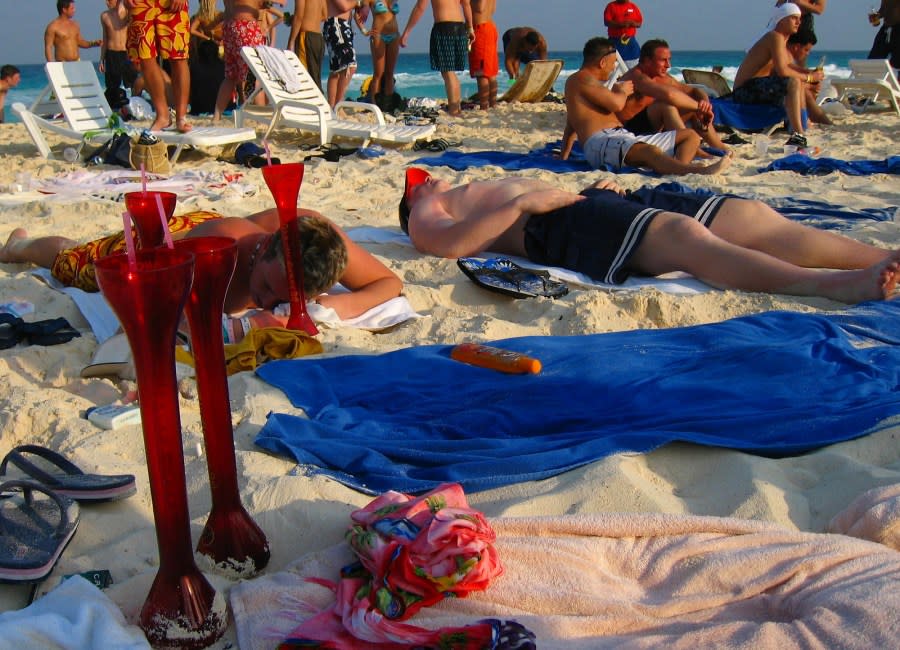 In this Monday March 17, 2003 file photo, students from the United Sates on spring break sunbathe at Cancun beach, Mexico. The U.S. State Department and universities around the country are warning college students headed for Mexico for some spring-break partying of a surge in drug-related murder and mayhem south of the border. (AP Photo/Jose Luis Magana, File)