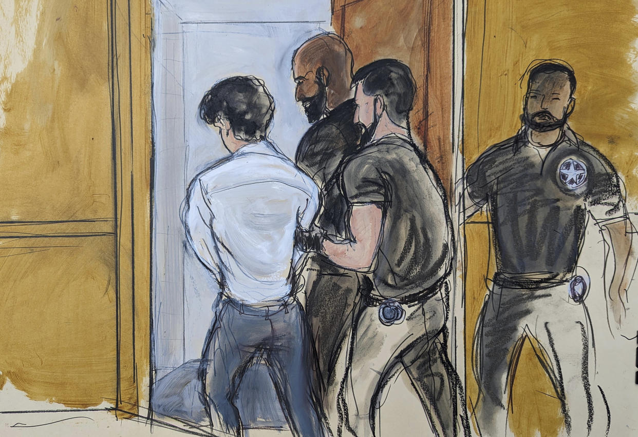 In this sketch, in Federal Court in New York, Friday, Aug. 11, 2023, FTX founder Sam Bankman-Fried is escorted by court officers from the courtroom. Bankman-Fried left the federal courtroom in handcuffs Friday after a judge revoked his bail after concluding that the fallen cryptocurrency wiz had repeatedly tried to influence witnesses against him. (AP Photo/Elizabeth Williams)