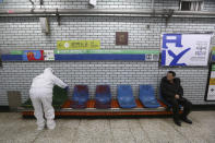 A worker wearing protective gears disinfect chairs as a precaution against the coronavirus at a subway station in Seoul, South Korea, Friday, Feb. 21, 2020. South Korea on Friday declared a "special management zone" around a southeastern city where a surging viral outbreak, largely linked to a church in Daegu, threatens to overwhelm the region's health system. (AP Photo/Ahn Young-joon)