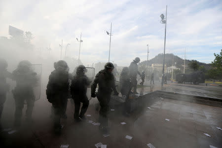 FILE PHOTO: Riot policemen disperse Mapuche indigenous activists (not pictured) during a protest demanding justice for Camilo Catrillanca, an indigenous Mapuche man who was shot in the head during a police operation, in Santiago, Chile December 14, 2018. REUTERS/Ivan Alvarado/File Photo