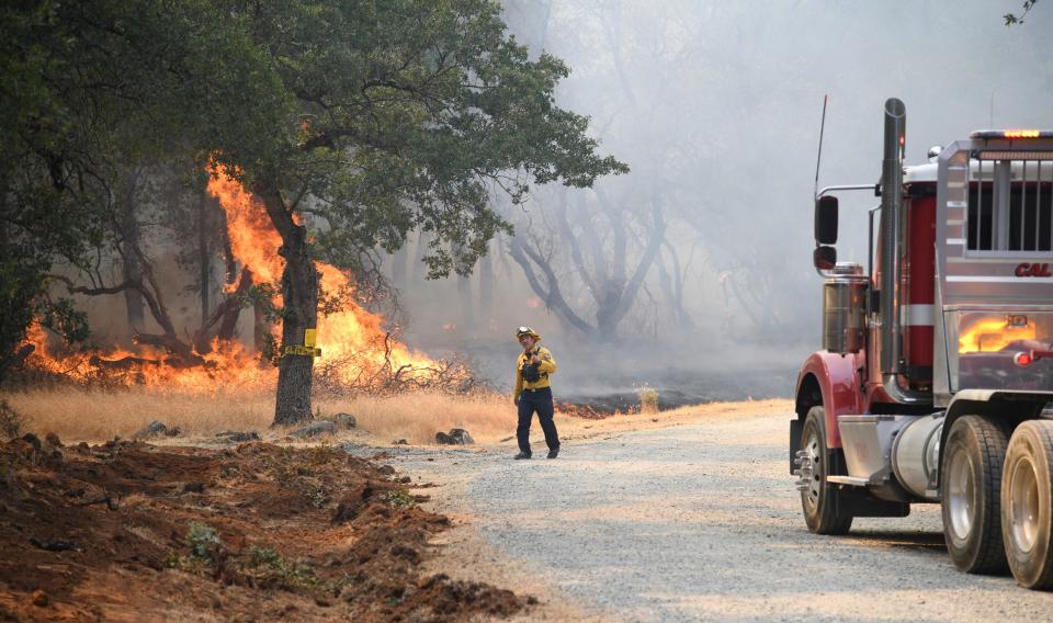 A firefighter assesses the approaching flames along Troost Trail in California's rural Nevada County as the Rices fire intensified.