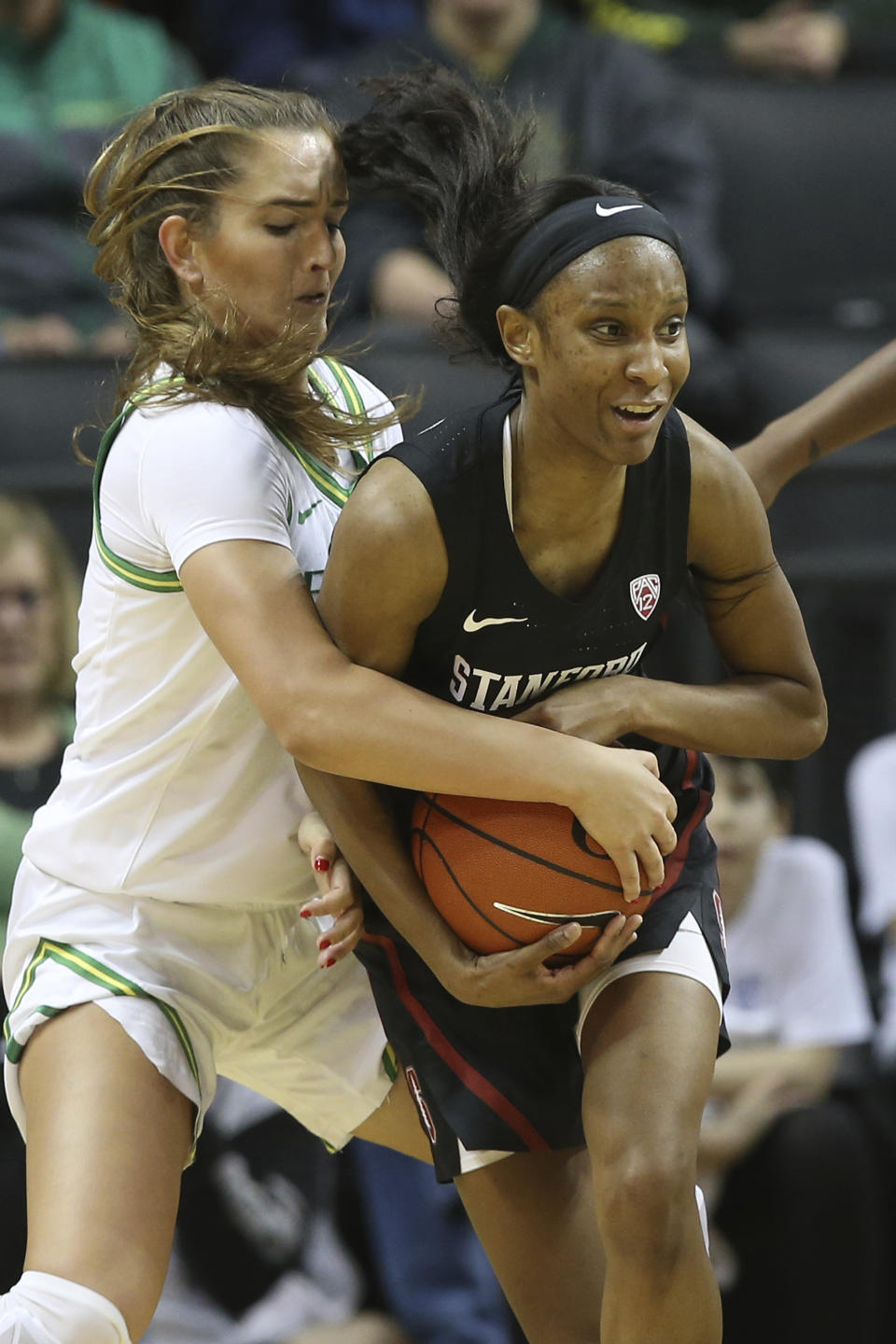 Oregon's Taylor Chavez, left, and Stanford's Kiana Williams struggle for the ball during the second quarter of an NCAA college basketball game in Eugene, Ore., Thursday, Jan. 16, 2020. (AP Photo/Chris Pietsch)