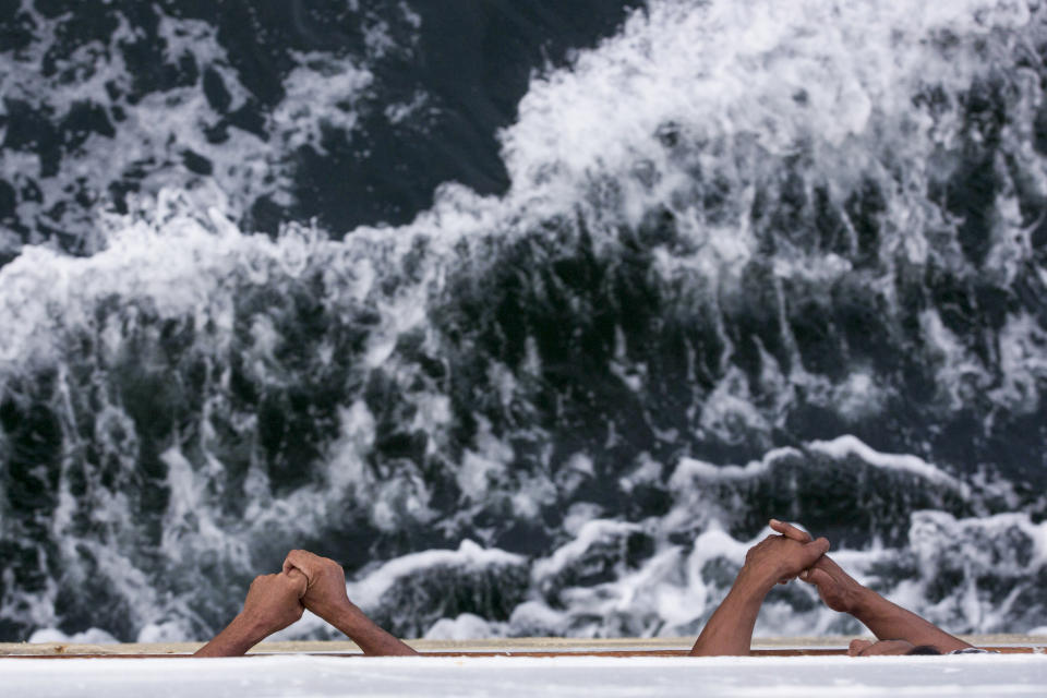 Two passengers look out to sea from a ferry headed to Nunukan, Indonesia on Monday, Dec. 3, 2018, the last stop before crossing the border to Malaysia. Many Indonesian workers from impoverished regions of their sprawling archipelagic nation sometimes travel for days by boat to find work on palm oil plantations in Malaysia. (AP Photo/Binsar Bakkara)