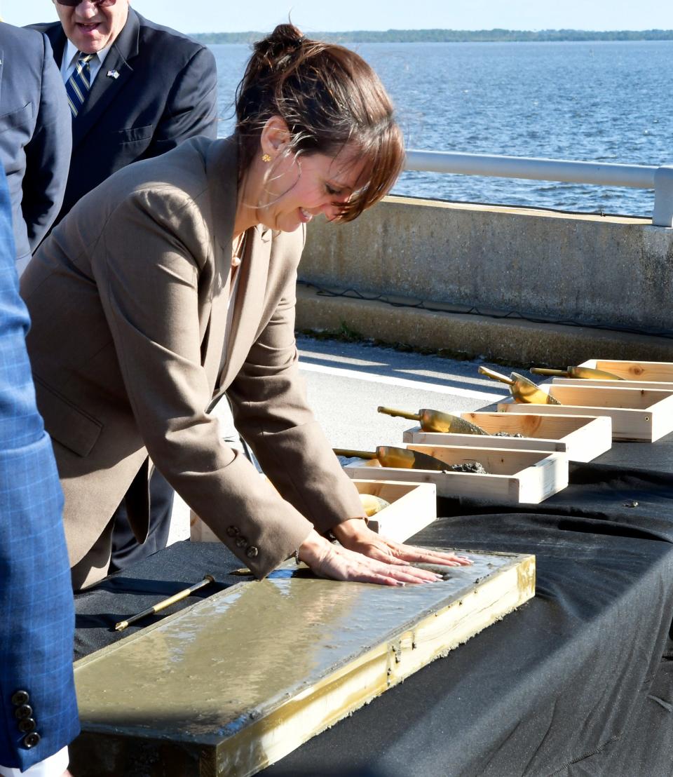 Florida Lt. Governor Jeanette Nunez, seen here making a hand print in concrete, was among the elected officials and guests at a Tuesday groundbreaking ceremony atop the bridge for a project that will reconstruct the NASA Causeway over the Indian River Lagoon.