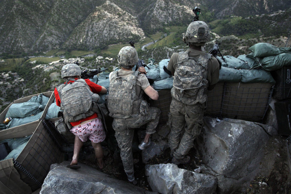 Soldiers from the U.S. Army First Battalion, 26th Infantry take defensive positions at firebase Restrepo after receiving fire from Taliban positions in the Korengal Valley of Afghanistan's Kunar Province on May 11, 2009. Spc. Zachary Boyd of Fort Worth, TX, far left was wearing 'I love NY' boxer shorts after rushing from his sleeping quarters to join his fellow platoon members. From far right is Spc. Cecil Montgomery of Many, LA and Jordan Custer of Spokan, WA, center. (AP Photo/David Guttenfelder, File)