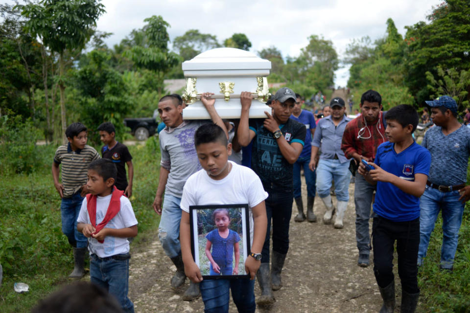 A boy carries a picture of Guatemalan seven-year-old Jakelin Caal, who died in a Texas hospital two days after being taken into custody by US border patrol agents in a remote stretch of the New Mexico desert.