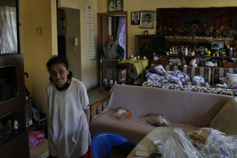 Marie Orfali, 76, left, and her husband Raymond, pose for a photograph in their apartment in Beirut, Lebanon, Tuesday, June 15, 2021. Tiny and bowed by age, Orfali makes the trip five times a week from her Beirut apartment to the local church, a charity and a nearby soup kitchen to fetch a cooked meal for her and her 84-year-old husband. (AP Photo/Hassan Ammar)