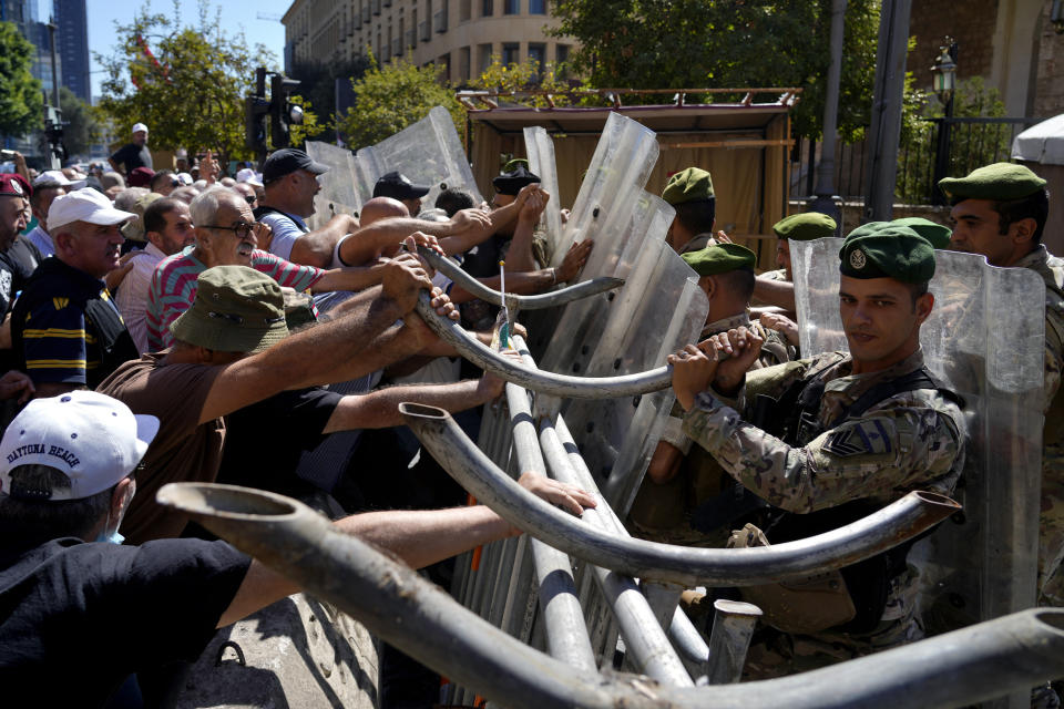 Soldiers scuffle with retired army members as they try to enter to the parliament building while the legislature was in session discussing the 2022 budget in downtown Beirut, Lebanon, Monday, Sept. 26, 2022. The protesters demanded an increase in their monthly retirement pay, decimated during the economic meltdown. (AP Photo/Bilal Hussein)