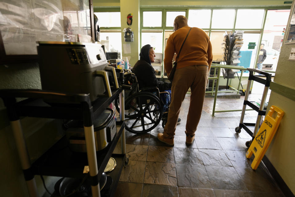 Peer advocate Anthony Hardnett assists a person at the Hospitality House in San Francisco, Wednesday, Feb. 7, 2024. A measure aimed at transforming how California spends money on mental health will go before voters in March as the state continues to grapple with an unabated homelessness crisis. Hospitality House's programs are among a slew of prevention services that would face significant budget cuts if Proposition 1 passes. (AP Photo/Eric Risberg)