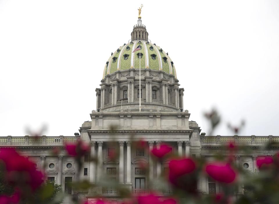 The state Capitol in Harrisburg is shown with roses in the foreground on May 23, 2017.