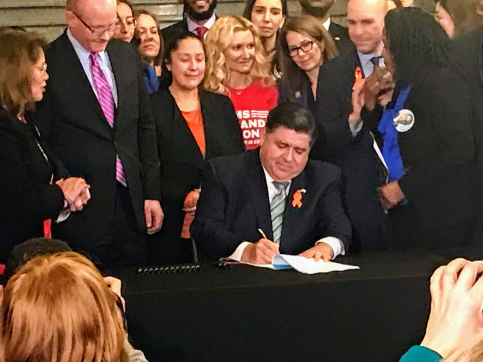 Gov. JB Pritzker, flocked by legislators and gun safety advocates, signed the Protect Illinois Communities Act on Tuesday, Jan. 10, 2023 to ban assault-style weapons, attachments, and high-capacity magazines in Illinois.