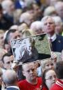 A man holds up a picture of a victim during a memorial service to mark the 25th anniversary of the Hillsborough disaster at Anfield in Liverpool, northern England April 15, 2014. REUTERS/Darren Staples
