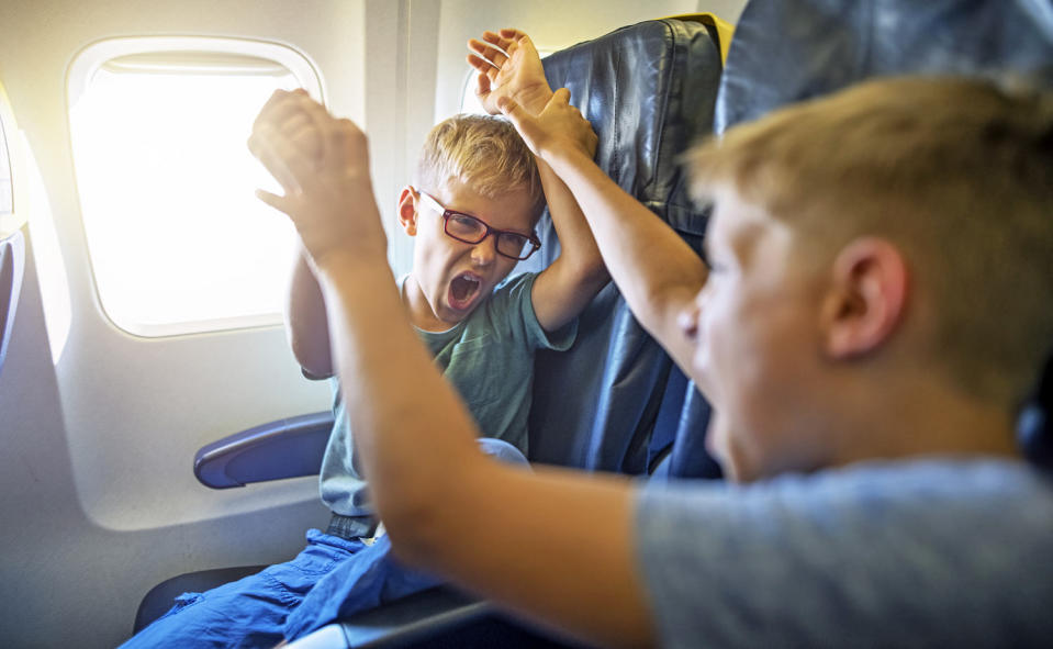 Two loud and mischievous boys fighting and yelling on a plane. (Getty Images)