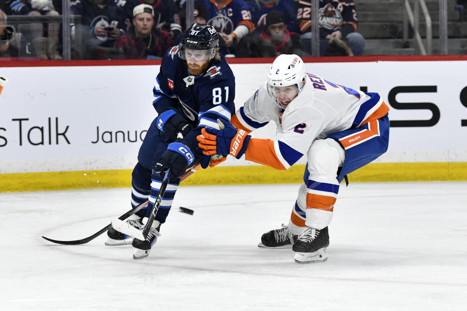 Winnipeg Jets' Kyle Connor (81) shoots as he skates past New York Islanders' Mike Reilly (2) during the second period of an NHL hockey game Tuesday, Jan. 16, 2024, in Winnipeg, Manitoba. (Fred Greenslade/The Canadian Press via AP)