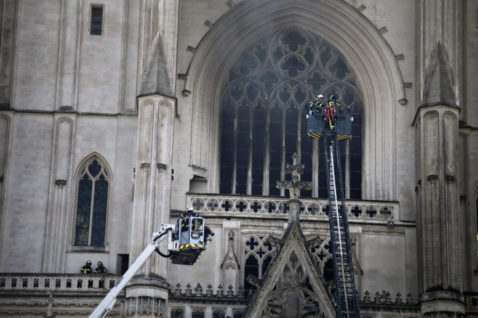 Fire fighters brigade work to extinguish the blaze at the Gothic St. Peter and St. Paul Cathedral, in Nantes, western France, Saturday, July 18, 2020. The fire broke, shattering stained glass windows and sending black smoke spewing from between its two towers of the 15th century, which also suffered a serious fire in 1972. The fire is bringing back memories of the devastating blaze in Notre Dame Cathedral in Paris last year that destroyed its roof and collapsed its spire and threatened to topple the medieval monument. (AP Photo/Romain Boulanger)