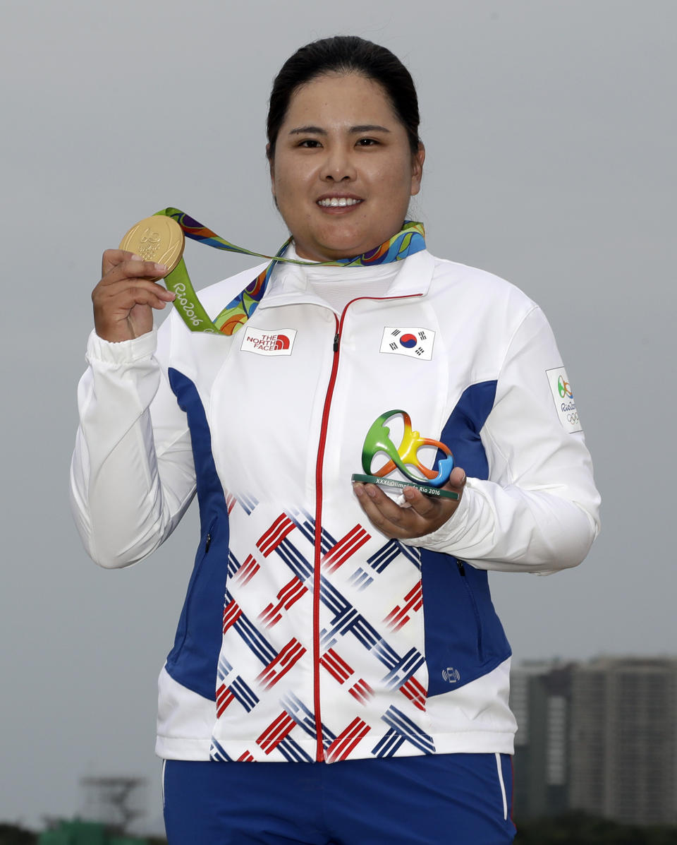 FILE - In this Aug. 20, 2016, file photo, Inbee Park, of South Korea, holds up her gold medal after the final round of women's golf at the Summer Olympics in Rio de Janeiro, Brazil. With the postponement of the Tokyo Games, Park gets more time to try to boost her world ranking and try to defend her gold medal in 2021. (AP Photo/Chris Carlson, File)