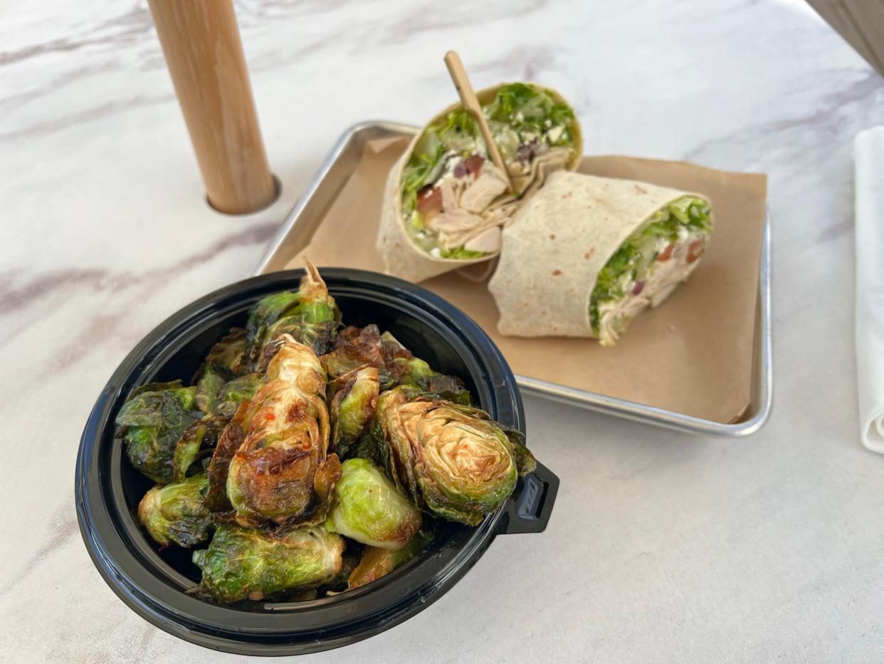 Menu items at Playdate, a bar and restaurant in Nashville, include crispy hot honey brussels sprouts and a Mediterranean chicken wrap.