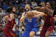 Cleveland Cavaliers guard Ricky Rubio (3) and center Evan Mobley (4) defend against a drive to the basket by Dallas Mavericks' Maxi Kleber (42) in the first half of an NBA basketball game in Dallas, Monday, Nov. 29, 2021. (AP Photo/Tony Gutierrez)