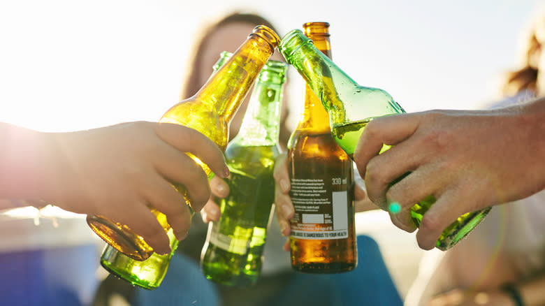 Group of people clinging beer bottles