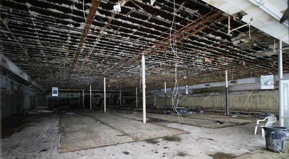 The interior of the former High Point Furniture store is seen through an unsecured door next to a chained door at the Midway Plaza on Wednesday in Tallmadge.