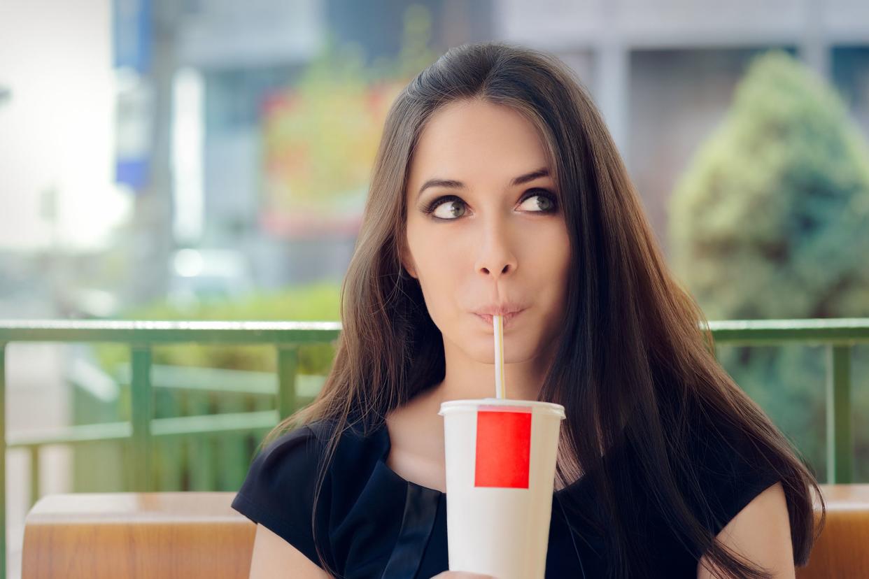 Woman drinking instant soda through a straw