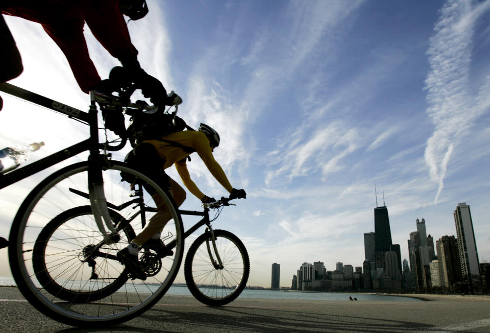 FILE - In this April 11, 2006 file photo, two cyclists pedal along Lake Michigan in Chicago, during the early morning hours. The lake's shoreline views are one of the free activities visitors can enjoy in Chicago. (AP Photo/Charles Rex Arbogast, File)