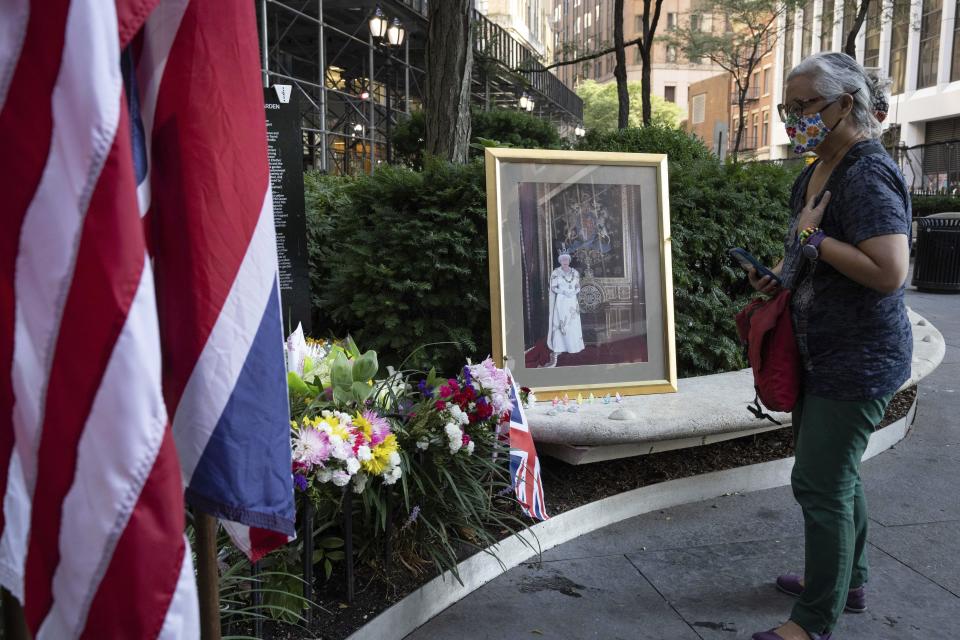 People visit a makeshift memorial after the death of Britain's longest-serving monarch Queen Elizabeth II at The Queen Elizabeth II 9/11 Garden, Friday, Sept. 9, 2022, in New York. (AP Photo/Yuki Iwamura)
