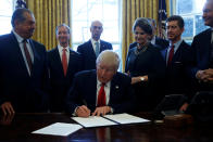 U.S. President Donald Trump is surrounded by business leaders as he signs an executive order on regulatory reform at his desk in the Oval Office at the White House, U.S. February 24, 2017. REUTERS/Jonathan Ernst