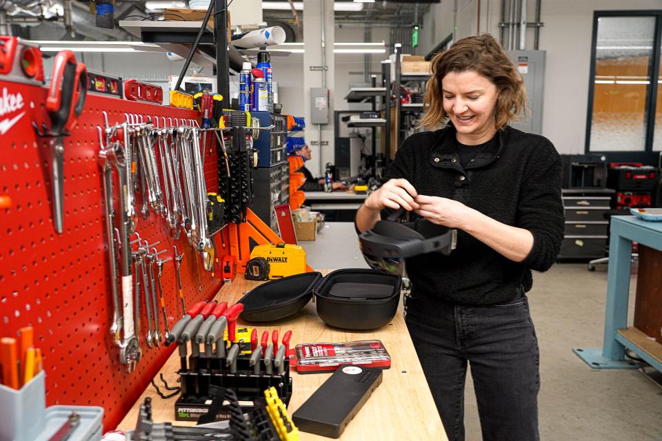 Corrie Van Sice, a research scientist associate, unpacks a Microsoft HoloLens II on a Texas Robotics lab workbench.