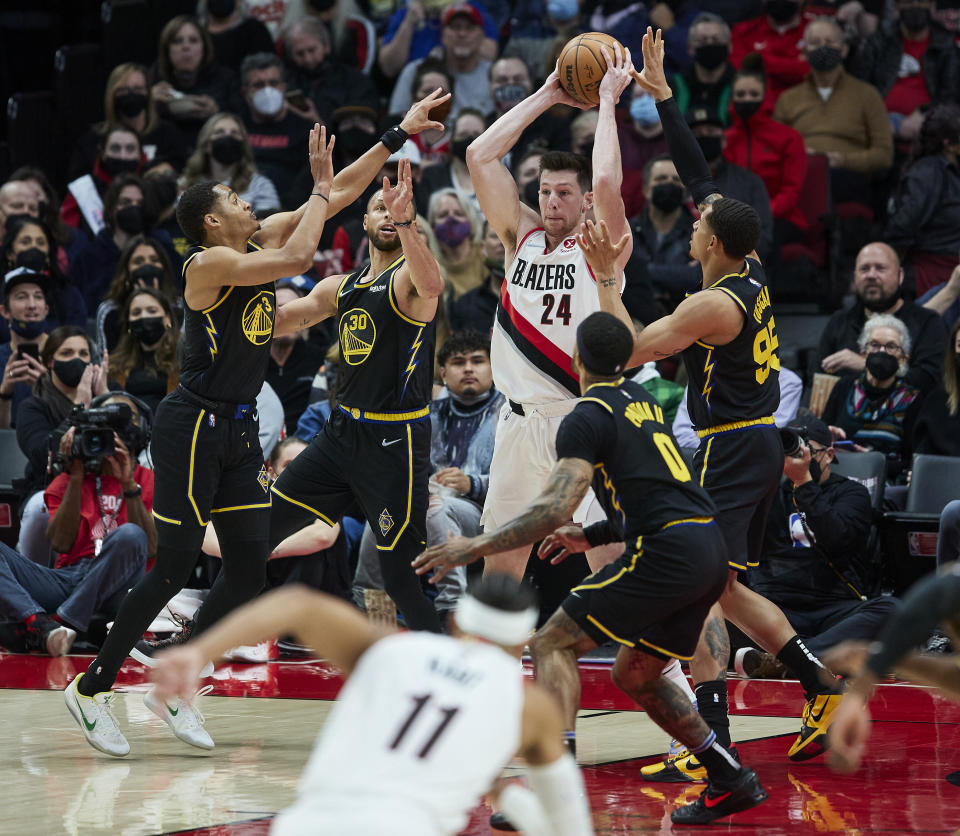 Portland Trail Blazers center Drew Eubanks, center, is surrounded by Golden State Warriors forward Otto Porter Jr., left, guard Stephen Curry, second from left, forward Juan Toscano-Anderson, right, and guard Gary Payton II during the first half of an NBA basketball game in Portland, Ore., Thursday, Feb. 24, 2022. (AP Photo/Craig Mitchelldyer)