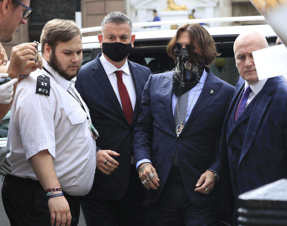 Actor Johnny Depp, second right, arrives at the High Court for a hearing in his libel case, in London, Friday, July 24, 2020. Depp is suing News Group Newspapers, publisher of The Sun, and the paper's executive editor, Dan Wootton, over an April 2018 article that called him a "wife-beater." The Sun's defense relies on a total of 14 allegations by his ex-wife, actress Amber Heard of Depp's violence. He strongly denies all of them. (Aaron Chown/PA via AP)