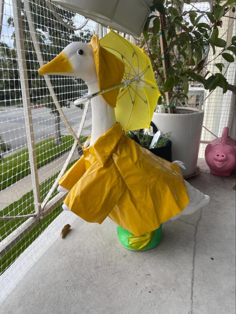 Good statue with yellow rain coat, matching hat, and umbrella