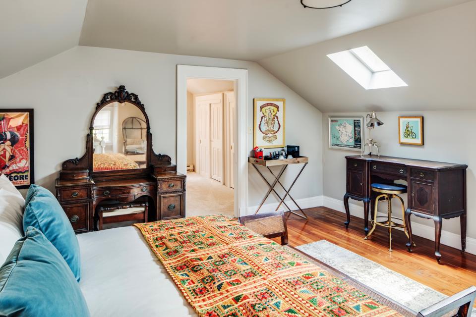 On the top floor of The Applewood Manor's main house, The Winesap Suite encompasses a traditional sitting area, a writing desk, and a vanity.