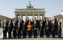 FILE - German Chancellor Angela Merkel, center front, gestures while standing with other EU leaders in front of the Brandenburg Gate in Berlin, on March 25, 2007. Merkel has been credited with raising Germany’s profile and influence, helping hold a fractious European Union together, managing a string of crises and being a role model for women in a near-record tenure. Her designated successor, Olaf Scholz, is expected to take office Wednesday, Dec. 8, 2021. (AP Photo/Michael Sohn, File)