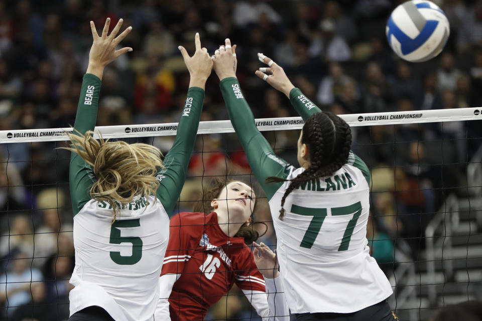 FIEL - Wisconsin's Dana Rettke (16) gets a spike by Baylor's Shelly Stafford (5) and Gia Milana (77) during a semifinal game of the NCAA Div I Women's Volleyball Championships in Pittsburgh, in this Thursday, Dec. 19, 2019, file photo. Wisconsin will open the reconfigured women's volleyball season ranked first in the nation. Women's volleyball will be the first of the NCAA fall sports to play this spring after the COVID-19 pandemic prompted most conferences to cancel or shorten their 2020 fall seasons and the NCAA to call off the national tournament. (AP Photo/Keith Srakocic, FIie)